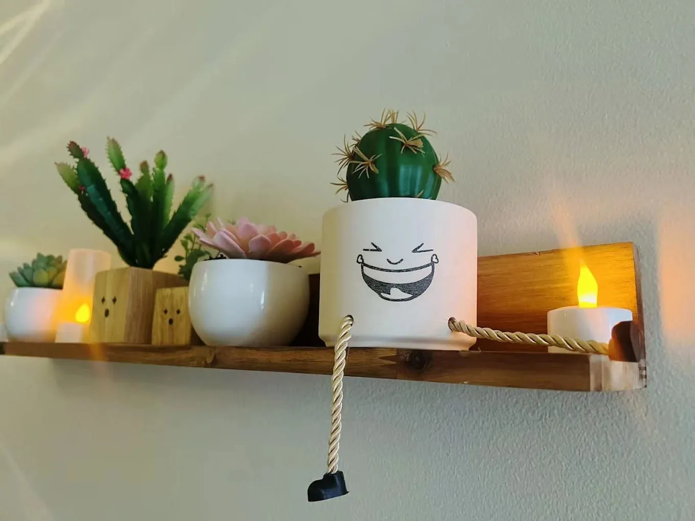 A wall shelf of potted succulents and flameless candles at Crystal Massage in Wichita, Kansas